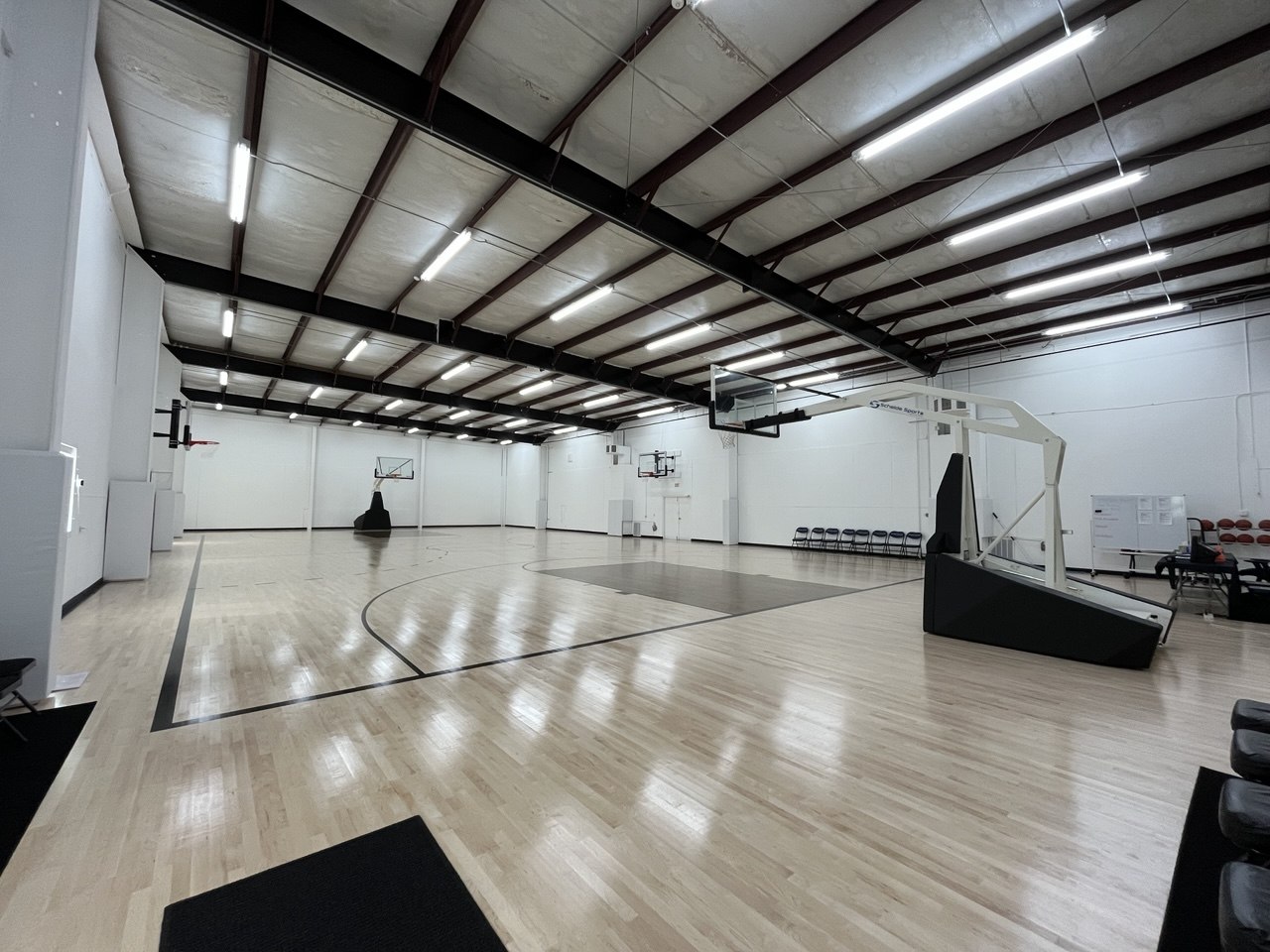 Wide view of the professional practice gym with multiple basketball hoops