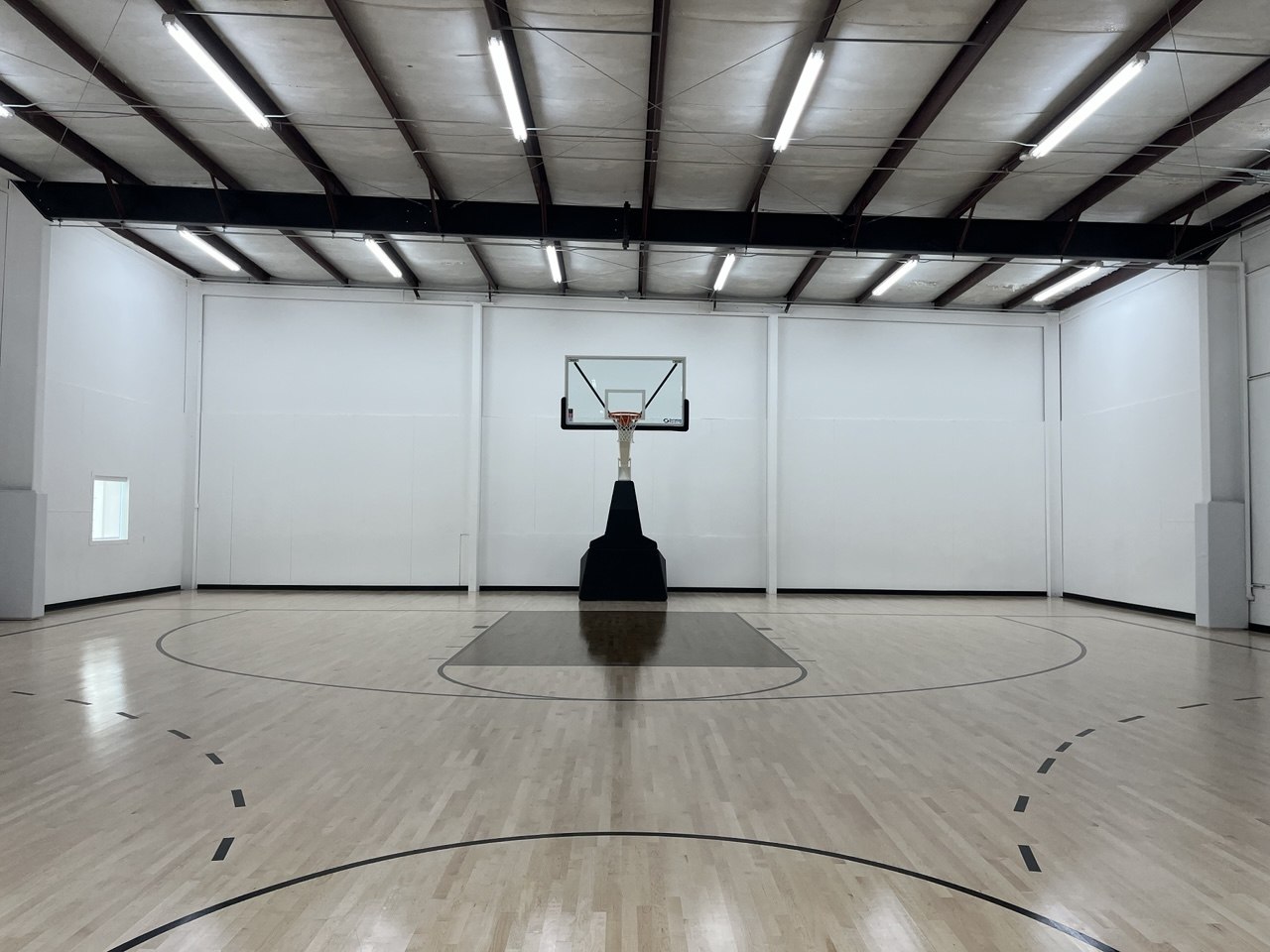 Symmetrical view down the private basketball court toward the hoop